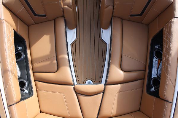 Slide: The Image of 2017 Nautique Super Air G23 interior with tan leather seats and cup holders. - 23