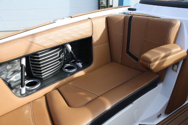 Slide: The Image of 2017 Nautique Super Air G23 interior with tan leather seating and cup holders. - 24