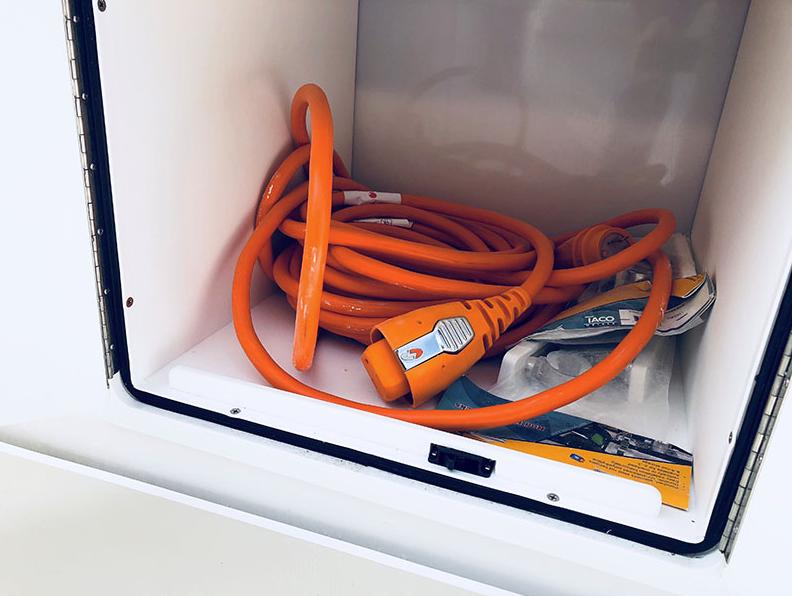 Slide: The Image of Orange power cable stored in a compartment of a 2024 NorthCoast 285HT boat. - 14
