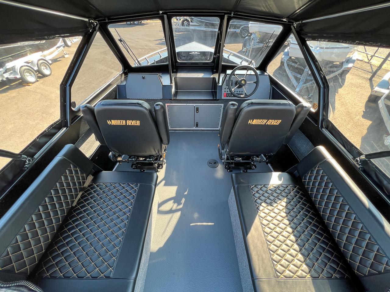 Slide: The Image of Interior of 2024 North River 21 SEAHAWK boat with black leather seating and steering console. - 8