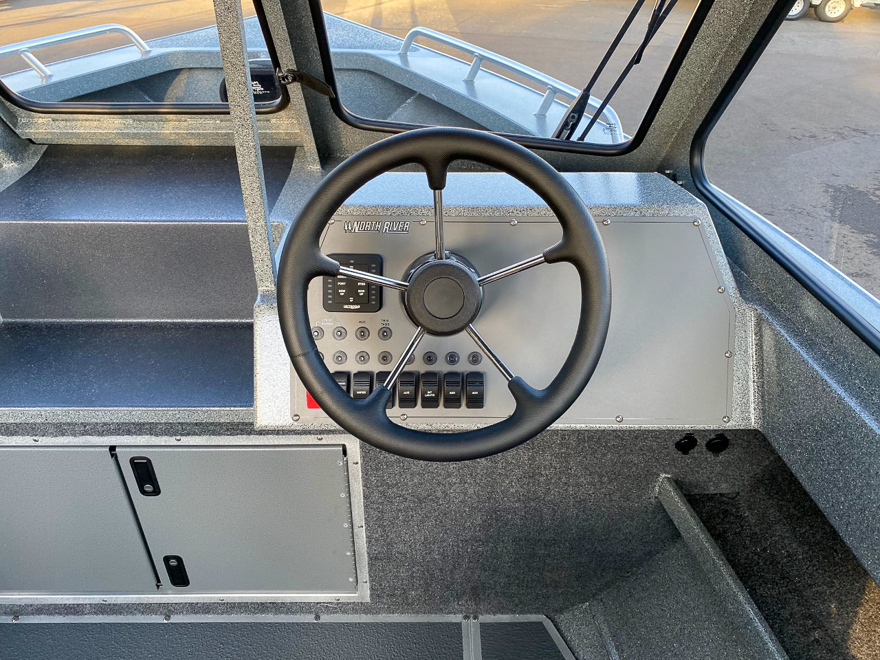 Slide: The Image of 2025 North River 22 Seahawk boat dashboard with steering wheel and control panel. - 13