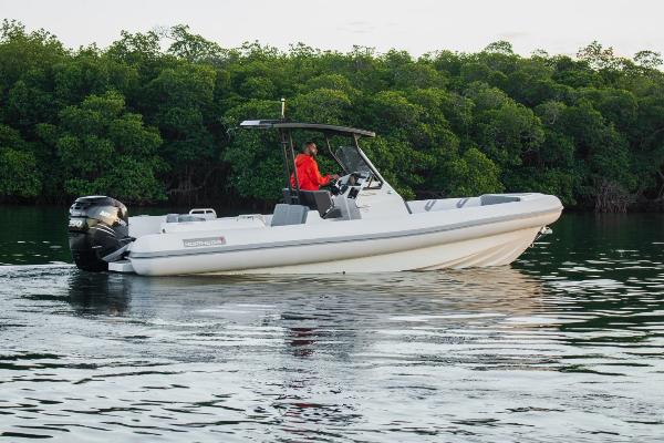 Slide: The Image of 2024 Northstar Orion 8 boat cruising on calm water near lush greenery. - 0