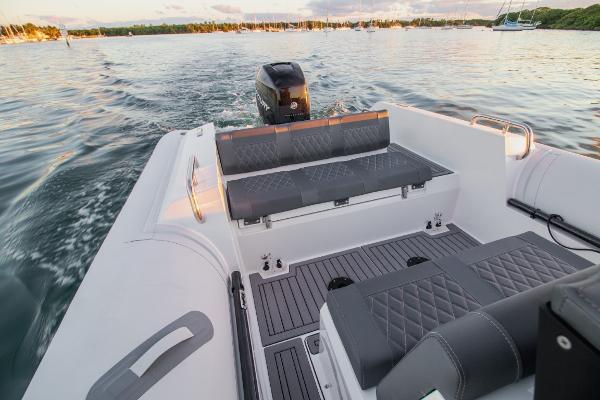 Slide: The Image of 2024 Northstar Orion 8 boat interior with cushioned seating and outboard motor on water. - 12