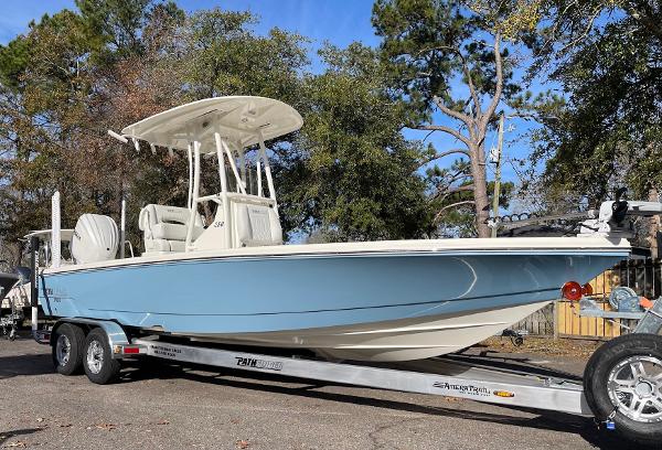 Slide: The Image of 2024 Pathfinder 2500 Hybrid boat on trailer, blue hull, parked outdoors. - 0