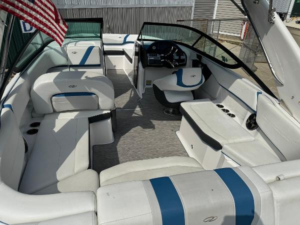 Slide: The Image of 2016 Regal 22 FasDeck ESX boat interior with white and blue seating, American flag. - 14