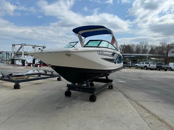 Slide: The Image of 2016 Regal 22 FasDeck ESX boat on a trailer at a marina. - 2