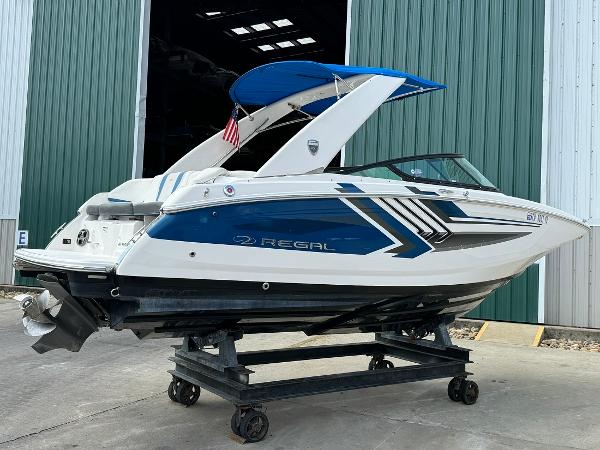 Slide: The Image of 2016 Regal 22 FasDeck ESX boat on a trailer outside a green warehouse. - 7