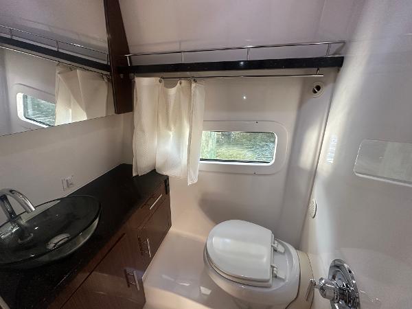 Slide: The Image of 2014 Regal 32 Express bathroom with modern sink, toilet, and window. - 10