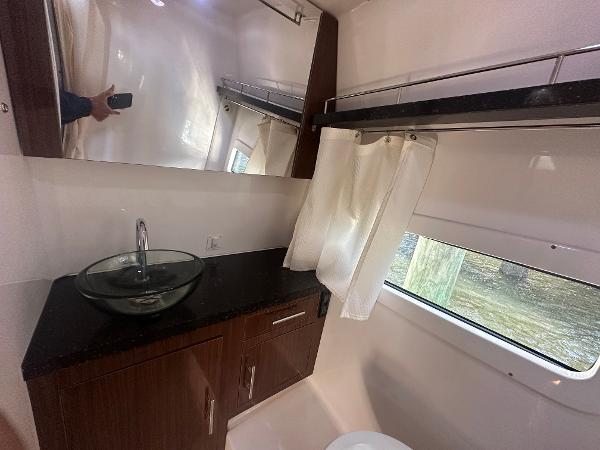 Slide: The Image of 2014 Regal 32 Express bathroom with modern sink, mirror, and window. - 11