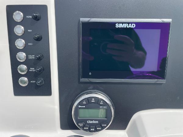 Slide: The Image of 2023 Robalo R180 Center Console dashboard with Simrad display and Clarion audio controls. - 26