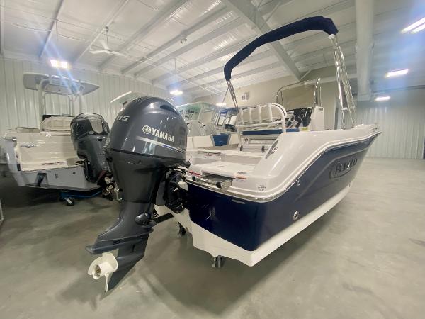 Slide: The Image of 2024 Robalo R180 Center Console boat with Yamaha outboard motor in a showroom. - 2