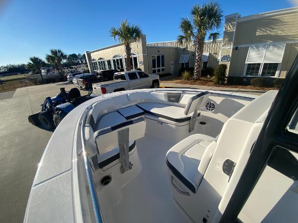 Slide: The Image of 2024 Robalo R200 Center Console boat with seating, parked outdoors near palm trees. - 11