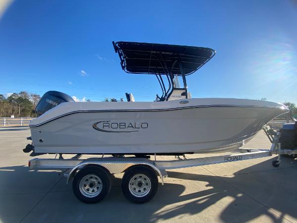 Slide: The Image of 2024 Robalo R200 Center Console boat on a trailer under clear blue sky. - 2