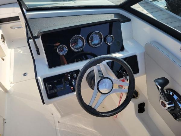 Slide: The Image of 2023 Sea Ray 230 SPX boat dashboard with steering wheel and control panel. - 1
