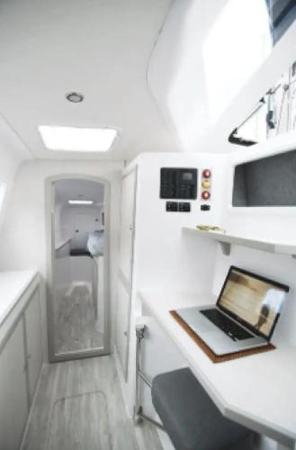 Slide: The Image of 2024 Seawind 1160 Lite interior with workspace and laptop. - 7
