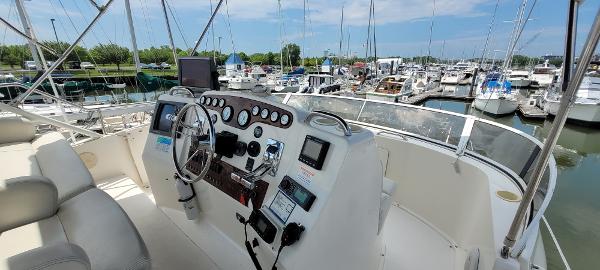 Slide: The Image of 2000 Silverton 392 Motor Yacht helm station at marina with boats in background. - 11