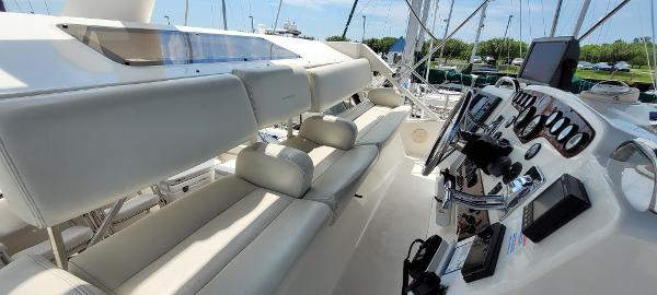 Slide: The Image of 2000 Silverton 392 Motor Yacht helm with white seating and control panel. - 12