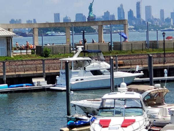 Slide: The Image of Silverton 392 Motor Yacht 2000 docked with Statue of Liberty and city skyline in background. - 2