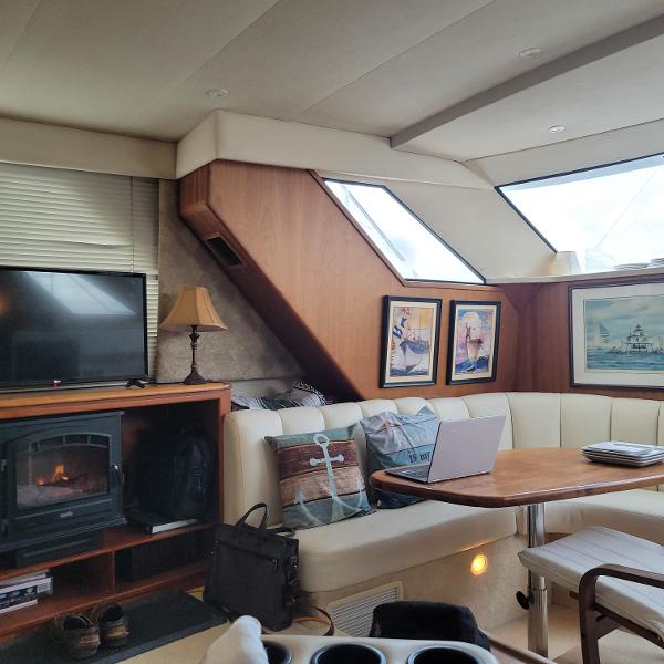 Slide: The Image of Interior of 2000 Silverton 392 Motor Yacht with cozy seating, table, and decor. - 22