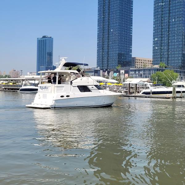 Slide: The Image of 2000 Silverton 392 Motor Yacht docked in a marina with city skyscrapers in the background. - 3