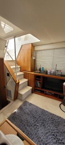 Slide: The Image of Interior of 2000 Silverton 392 Motor Yacht with stairs, carpet, and entertainment area. - 36
