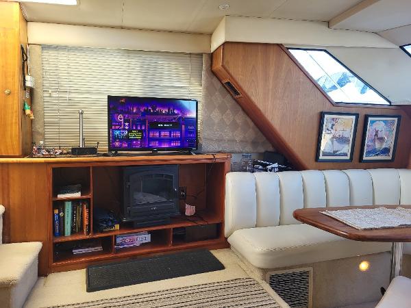 Slide: The Image of Interior of a 2000 Silverton 392 Motor Yacht with TV, seating, and wooden cabinetry. - 40