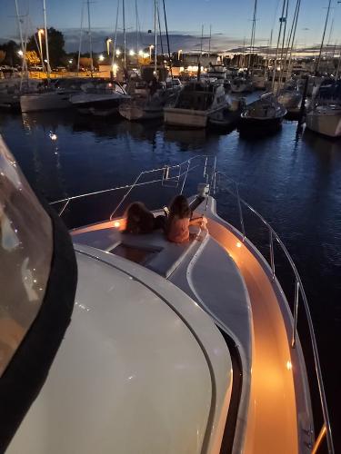 Slide: The Image of 2000 Silverton 392 Motor Yacht at dusk in a marina with two people on deck. - 44