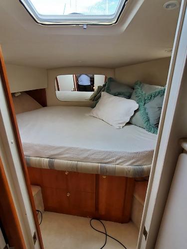 Slide: The Image of Cozy bedroom in a 2000 Silverton 392 Motor Yacht with skylight and plush pillows. - 47