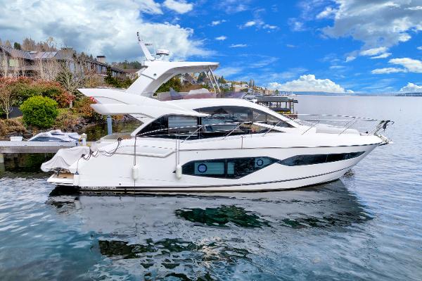 Slide: The Image of 2017 Sunseeker Manhattan 52 yacht docked by waterfront homes. - 0