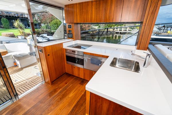 Slide: The Image of Modern kitchen on 2017 Sunseeker Manhattan 52 yacht with wood cabinetry and white countertops. - 12