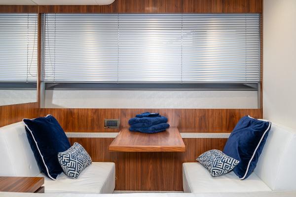 Slide: The Image of Sunseeker Manhattan 52 2017 yacht interior with dining area, blue cushions, and wooden table. - 29