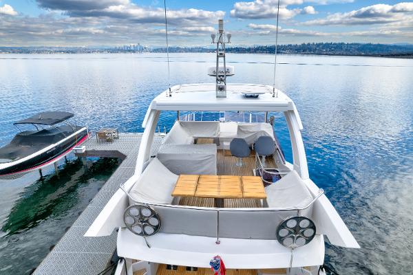 Slide: The Image of 2017 Sunseeker Manhattan 52 yacht docked on a serene lake with a cloudy sky. - 3