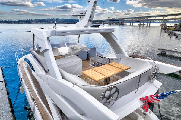 Slide: The Image of 2017 Sunseeker Manhattan 52 yacht docked, featuring spacious upper deck with seating and dining area. - 4