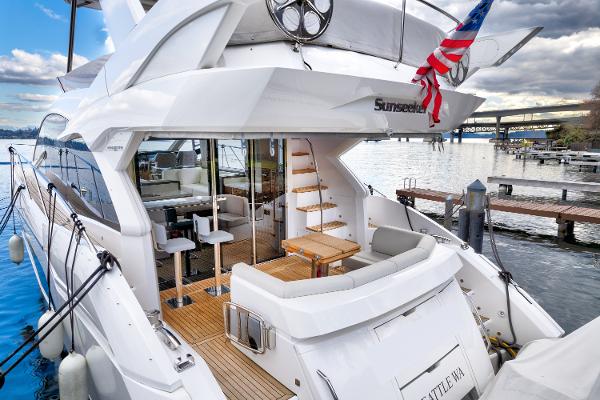 Slide: The Image of 2017 Sunseeker Manhattan 52 yacht docked, featuring spacious deck and luxurious seating. - 6