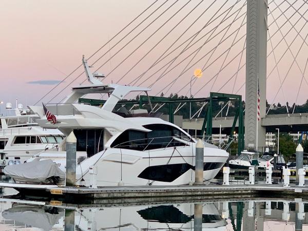 Slide: The Image of 2017 Sunseeker Manhattan 52 yacht docked at marina with bridge in background. - 7