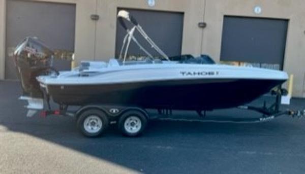 Slide: The Image of 2024 Tahoe T21 boat on a trailer in front of a building. - 0