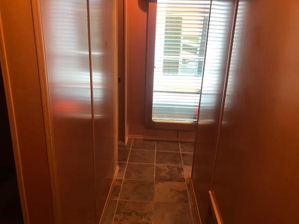 Slide: The Image of Narrow hallway in a 2007 Thoroughbred houseboat with tiled floor and window blinds. - 21