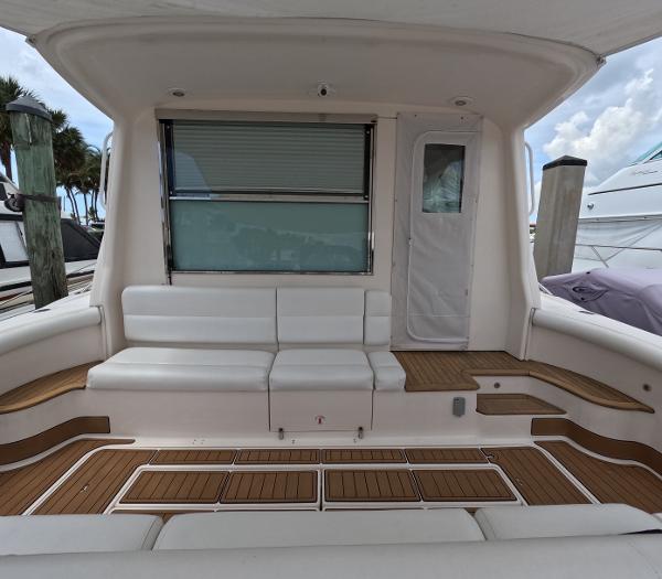 Slide: The Image of 2004 Tiara Yachts 5200 Sovran Salon, rear seating area with white cushions and teak flooring. - 5