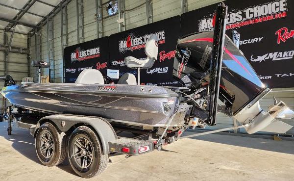 Slide: The Image of 2024 Triton 19 TrX Patriot boat in showroom, featuring sleek design and powerful engine. - 3