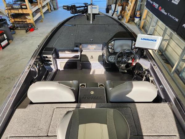 Slide: The Image of 2024 Triton 19 TrX Patriot boat interior with steering console and seating. - 4