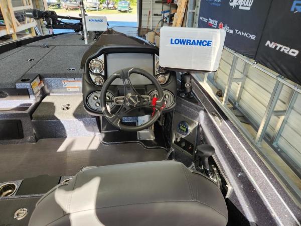 Slide: The Image of 2024 Triton 19 TrX Patriot boat cockpit with Lowrance electronics and steering wheel. - 6