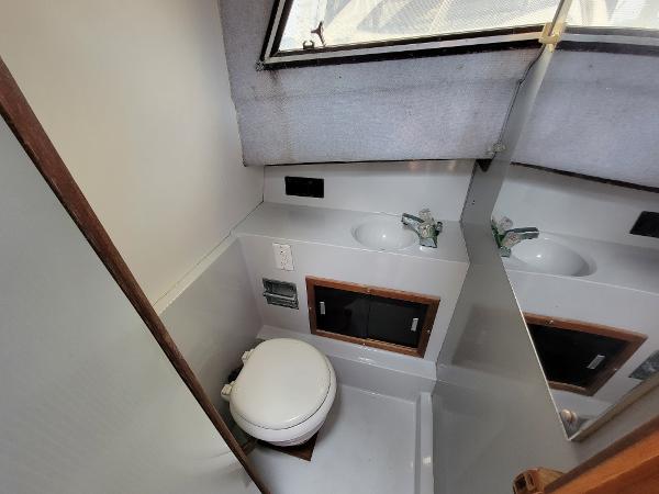 Slide: The Image of 1986 Wellcraft 2800 Coastal Offshore Fisherman boat bathroom with toilet, sink, and mirror. - 7